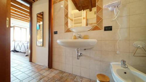 een badkamer met een wastafel en een bad bij MeA on the Lake Cavalcaselle in Cavalcaselle