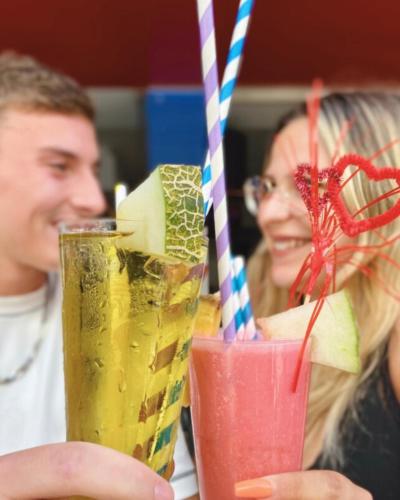 two people sitting at a table with two drinks at Vegas Residence - Adults Only in Albufeira