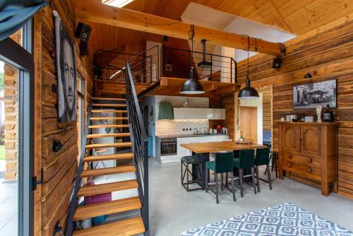 a kitchen and dining room with a spiral staircase in a log cabin at Grand Rozbój House Beskid Niski, Spa Ogrodowe 