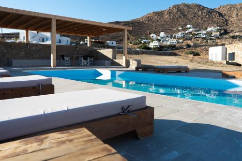una grande piscina con una couchituresituresermott bianca di Megusta Mykonos a Tourlos