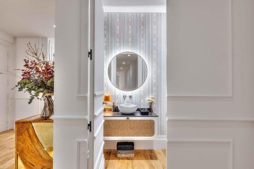 uma casa de banho com um espelho e um lavatório em Apartamento Canalejas Place en Madrid em Madri