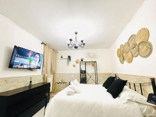 1 dormitorio con 1 cama blanca y TV de pantalla plana en Casa Vacanza Gentileschi - Self Check-in, en Nápoles