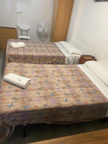 two beds in a hospital room with a bed sidx sidx sidx at La Ferroviaria - Habitaciones Con Baño Privado y Compartido - Sin Ascensor in Zaragoza