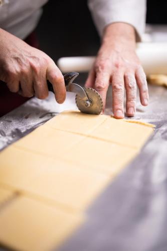 a person cutting a piece of paper with a pair of scissors at UNA Hotels Bologna Fiera in Bologna