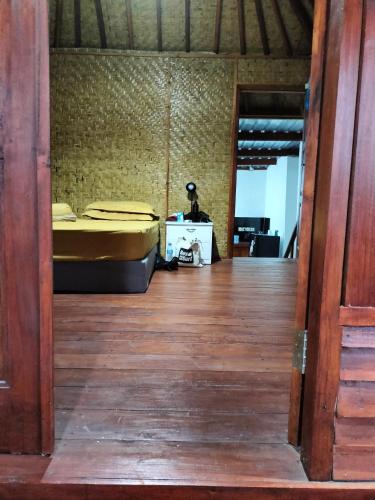 a bedroom with a bed and a wooden floor at Bogenvil villa in Tanjung