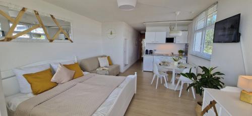 uma sala de estar com uma cama e uma cozinha em Pools, Sauna und Balkon mit Panoramablick em Sankt Englmar