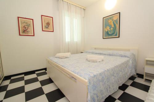 1 dormitorio con 1 cama y suelo a cuadros en Eco del Mare Apartments, en Lido di Pomposa