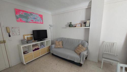a living room with a chair and a tv at La Casa del Bienestar in Cabra