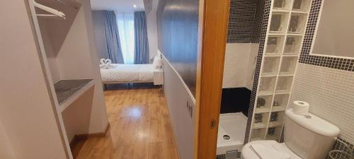 a small bathroom with a toilet and a bedroom at Hostal New Life Madrid in Madrid