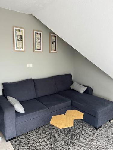- un canapé bleu dans le salon avec un escalier dans l'établissement Charmant studio à Cabourg Plage, à Cabourg