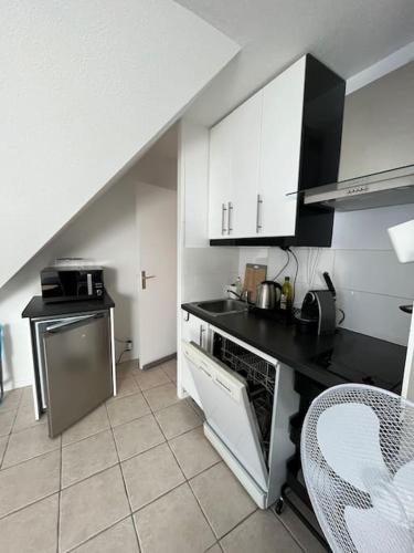 une cuisine avec un évier et un plan de travail dans l'établissement Charmant studio à Cabourg Plage, à Cabourg