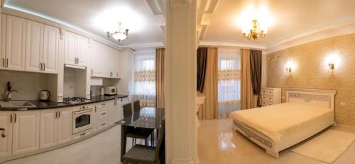 Il comprend une grande chambre avec un lit et une cuisine. dans l'établissement Apartments U Ratushi, à Kamianets-Podilsky