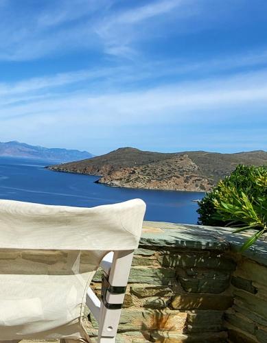 a white chair sitting on a wall next to the water at Andros Eco Home in Gavrion
