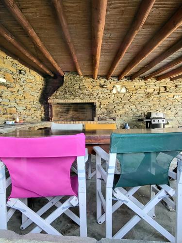a table and chairs in a room with a brick wall at Andros Eco Home in Gavrion