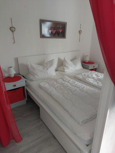 バート・ザクサにあるFerienwohnung Sweety Haus Sachsensteinblickのベッドルーム1室(ベッド2台、赤いカーテン付)
