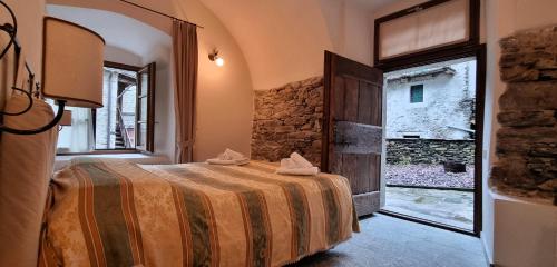 a bedroom with a bed and a large window at Dimora Storica Casa Vanni in Villadossola