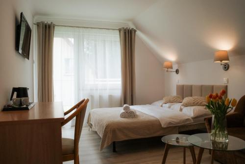 カルパチにあるWilla Skałkaのベッドルーム(ベッド1台、テーブル付)