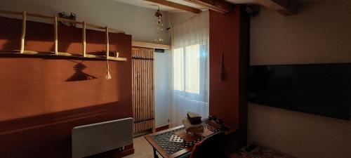 Malissard的住宿－L'OAZIS，客厅配有桌子和电视