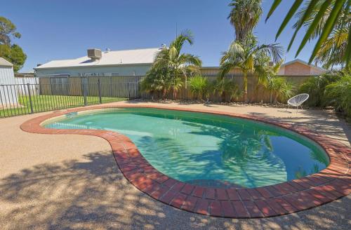 una pequeña piscina en un patio con palmeras en Varyam House, en Mildura