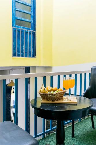 a table with a bowl of fruit and drinks on a balcony at Barefoot Boutique Hotel Udaipur in Udaipur