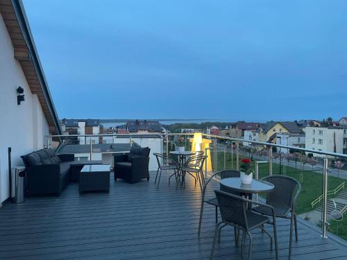 taras z krzesłami i stołami na balkonie w obiekcie La Mer Pokoje i Apartamenty we Władysławowie