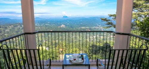 a table on a balcony with a view at Randholee Resort & Spa in Kandy