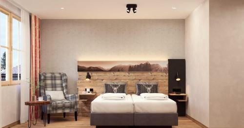 a bedroom with two beds and a table and chair at Hotel Auhof in Grossarl