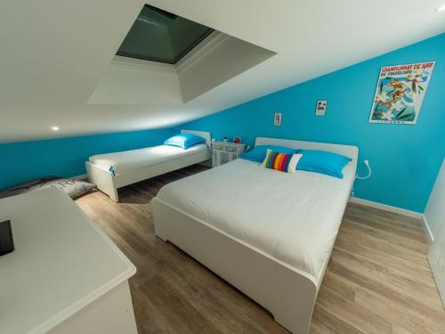 - une chambre avec des murs bleus, un lit et une table dans l'établissement Magnifique loft au coeur de Saint Gilles 5 pers, à Saint-Gilles-Croix-de-Vie