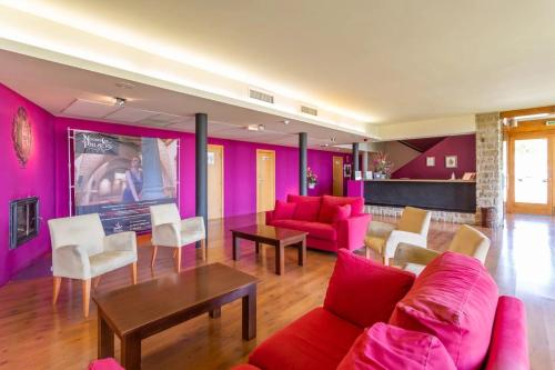 - un salon doté d'un mobilier rose et d'une table dans l'établissement Hotel Alda Triskel, à Sos del Rey Católico