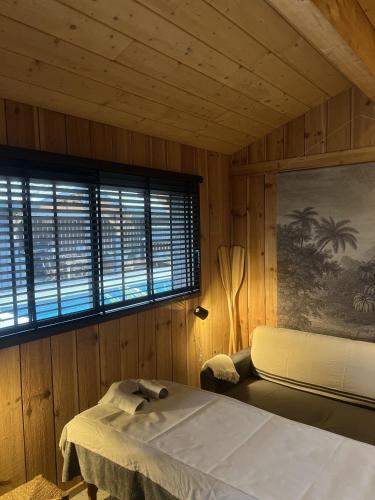 a wooden room with a bed and a window at VillaCanau in Lacanau