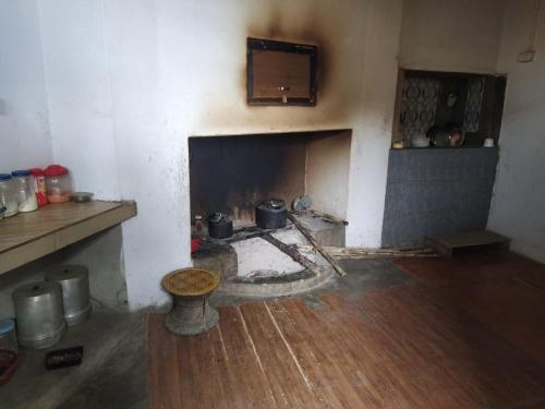 a room with a fireplace with pots and pans at Avi Homestay in Kohīma