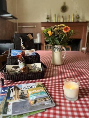 une table avec un vase de fleurs et une bougie dans l'établissement Demeure Familiale du 19ème Siècle, à Bram