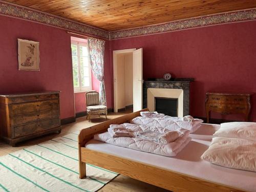 - une chambre avec un grand lit dans un mur rouge dans l'établissement Demeure Familiale du 19ème Siècle, à Bram