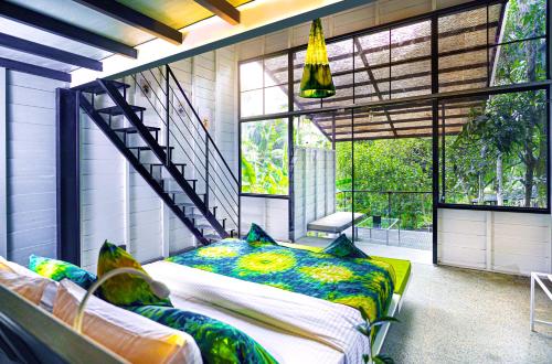 a bedroom with two beds in a room with windows at Waraka - Udawalawe by Thema Collection in Udawalawe