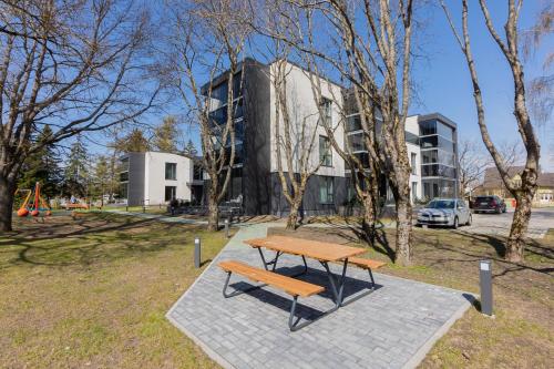 a wooden bench sitting in a park next to a building at Seafront Apartment in Pärnu