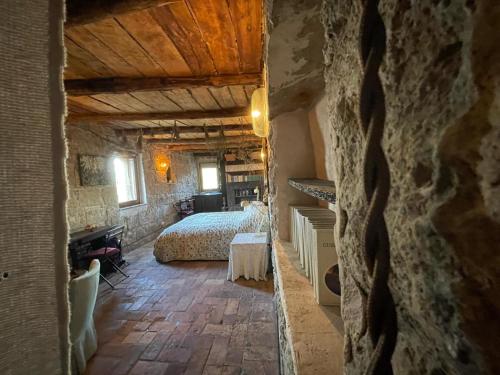 ein Schlafzimmer mit einem Bett in einem Steingebäude in der Unterkunft officina alchemica in Calcata