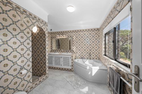 a bathroom with a tub and a toilet and a sink at Luxury Villa, Very Close to Beach + Restaurants, WI FI, Heatable Pool. in Sesmarias
