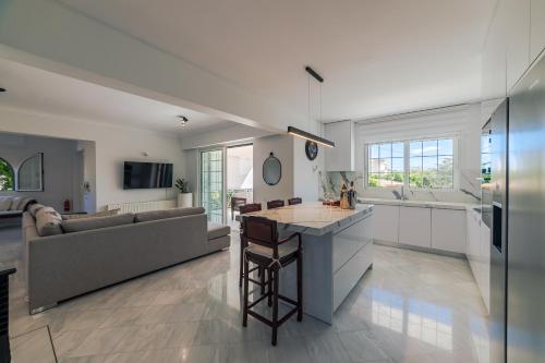 a kitchen and living room with a couch at Lagonisi Luxury Escape in Lagonissi