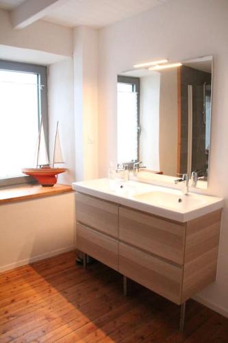 une salle de bain avec un lavabo et un grand miroir dans l'établissement La Romance,vue mer, jardin et proche plage, à Roscoff