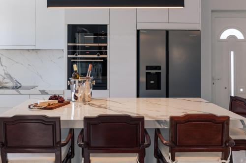 a kitchen with a large marble island with two chairs at Lagonisi Luxury Escape in Lagonissi