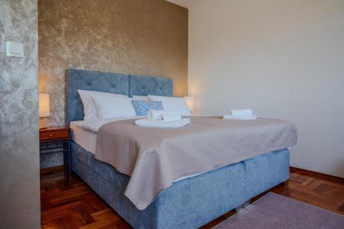 a bedroom with a blue bed with two towels on it at Vila Rosa in Vukovar