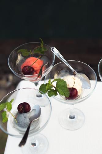 three bowls of ice cream and cherries on a table at Khla Lodge in Kampot