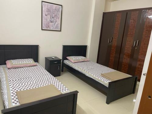 2 łóżka pojedyncze w pokoju z: w obiekcie Homestay w mieście Hajdarabad