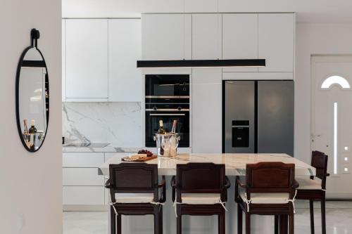 a kitchen with a large table and chairs at Lagonisi Luxury Escape in Lagonissi
