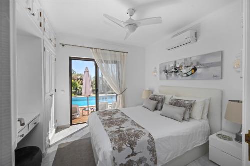 a white bedroom with a bed and a view of the ocean at Luxury Villa, Very Close to Beach + Restaurants, WI FI, Heatable Pool. in Sesmarias
