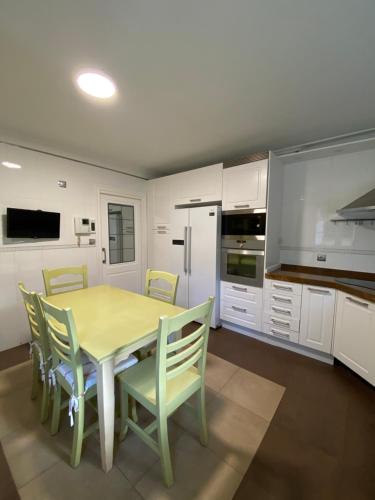 a kitchen with a dining room table and chairs at Chalet con Piscina Privada in Santander