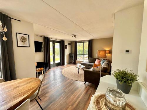 Ewijk的住宿－6p Boshuis 'De Groene Specht' met hottub，客厅配有沙发和桌子