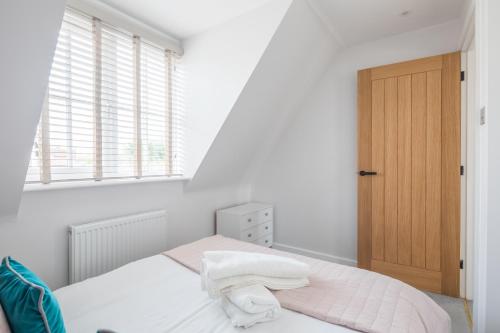 una camera da letto con un letto con lenzuola bianche e una finestra di Modern Stylish Cambridge Pad (Free Parking) a Histon