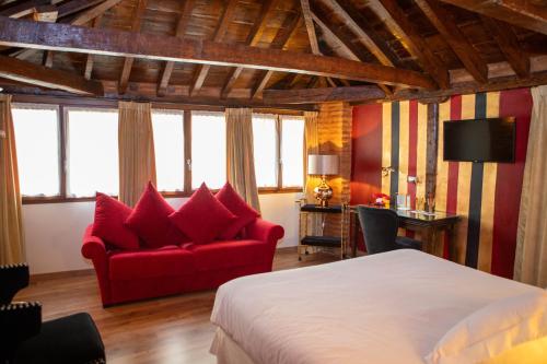 una camera da letto con un letto e un divano rosso di Hotel Boutique Posada Castañeda a Granada
