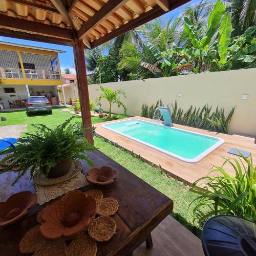 einen Pool im Hinterhof mit einem Tisch und einem Tisch in der Unterkunft Casa do Bougainvillea Mundaú-Trairi-Ce in Mundaú